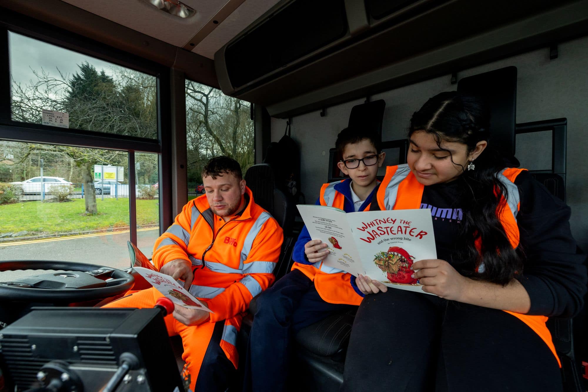 2 children and a Biffa driver reading the storybook