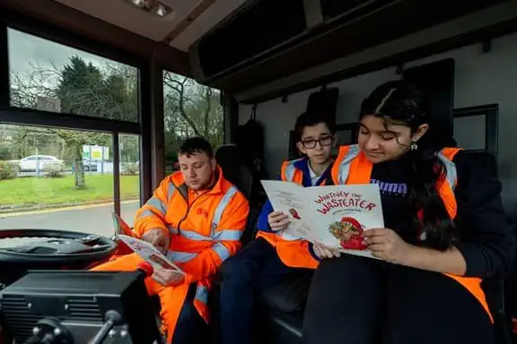 2 children and a Biffa driver reading the storybook