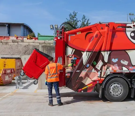 Employee loading bin into the back of truck