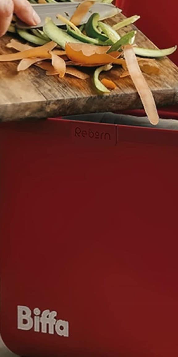 Food being scrapped into red kitchen caddy