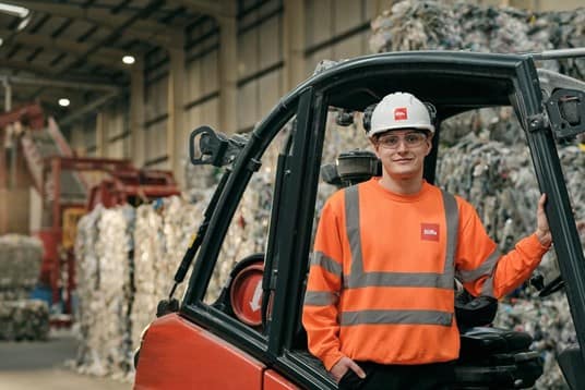 Biffa employee standing next to forklift