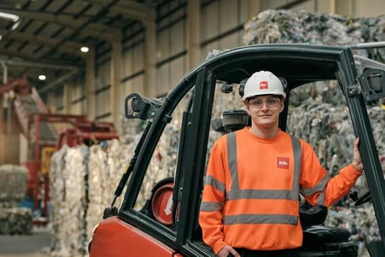 Biffa employee standing next to forklift