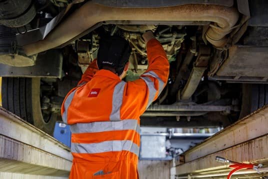 Employee working on the bottom of a truck