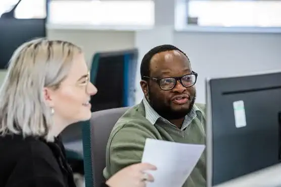 Female and male co worker looking at monitor