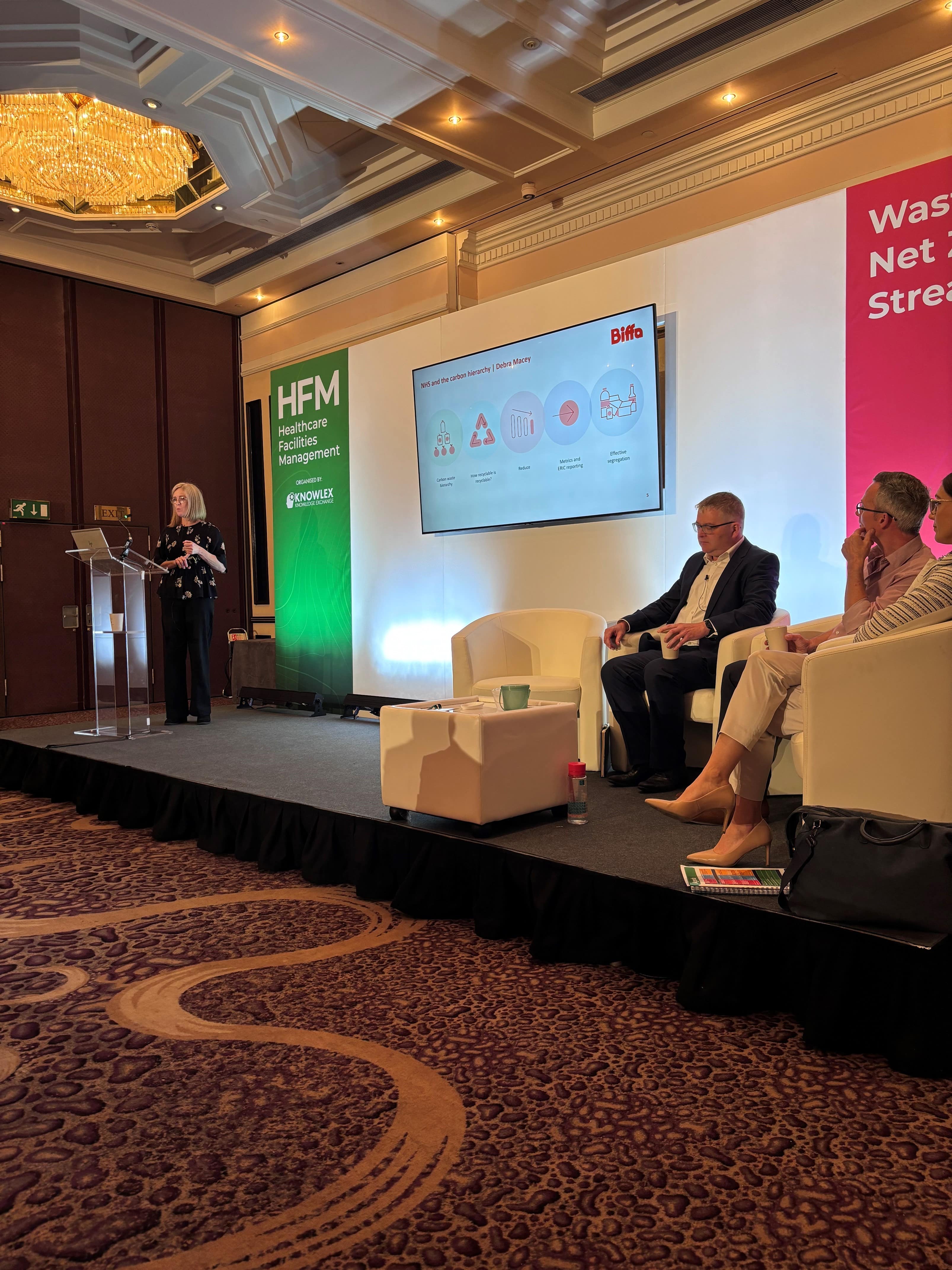 An image of a stage with Debs speaking to a crowd at HFM 2024.