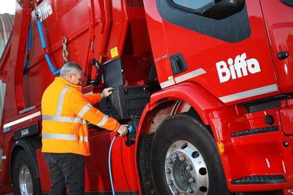 Man charging Biffa's first Volvo electric skip loader