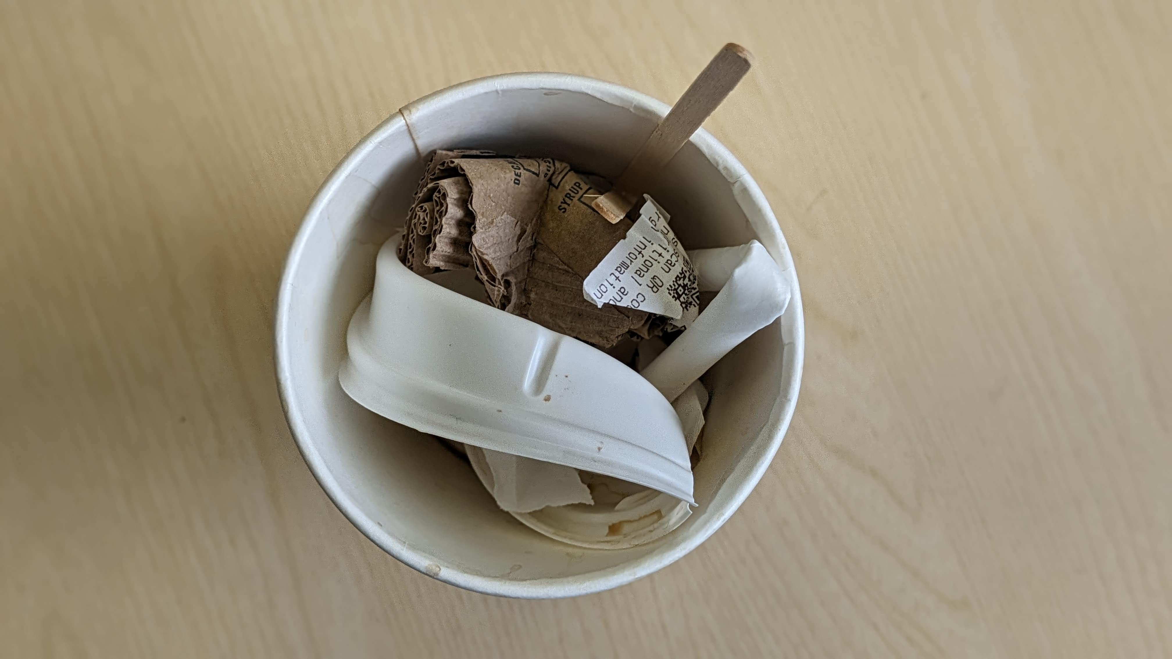 coffee cup with scrunched lid, exterior card and stick inside