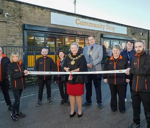 Ribbon cutting outside of Community Shop