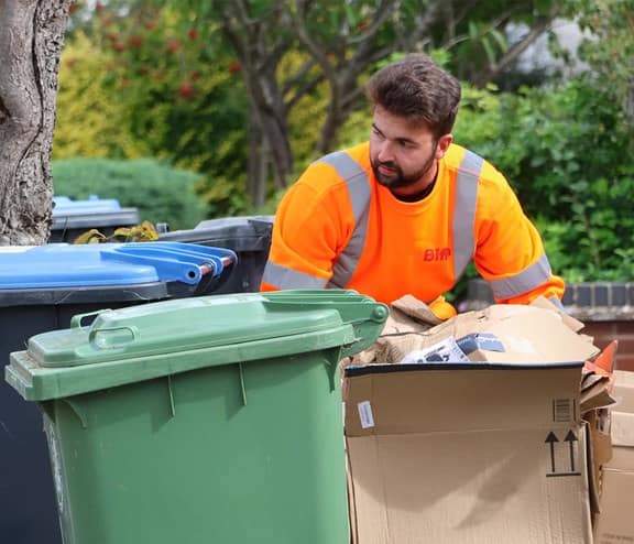 Biffa employee collecting bins in East Sussex after Biffa extends waste collection and cleaning contract