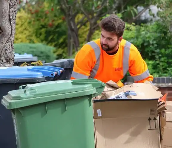 Biffa employee collecting bins in East Sussex after Biffa extends waste collection and cleaning contract