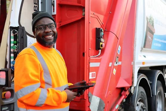 Employee smiling in front of a Biffa truck