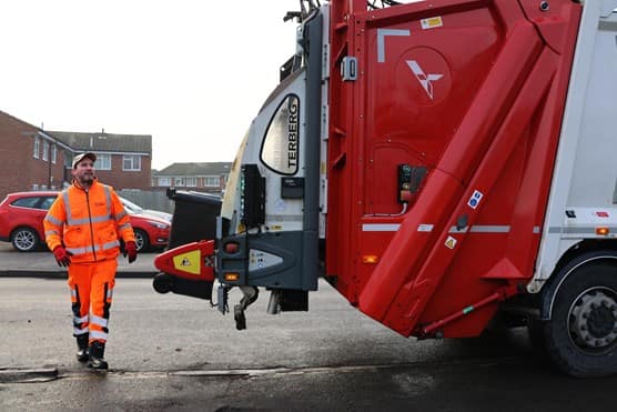 Employee loading bin into the back of truck