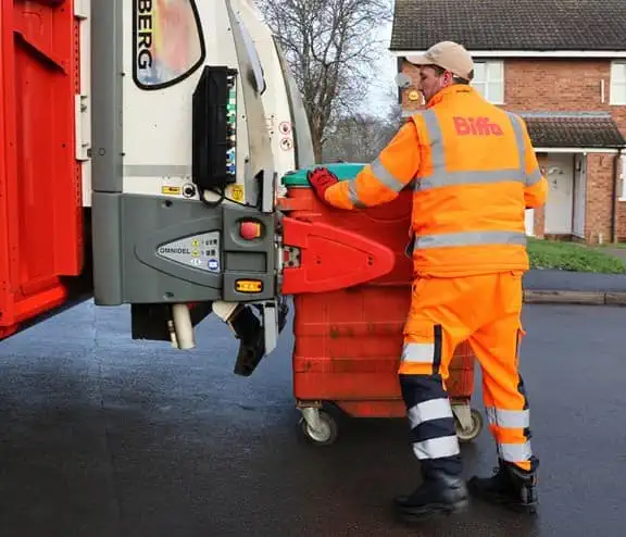 Employee loading bin into the back of truck