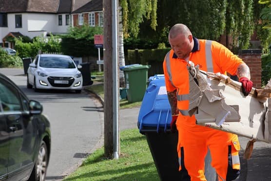 Employee with bin and cardboard waste