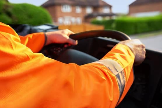 Driver in high vis holding steering wheel