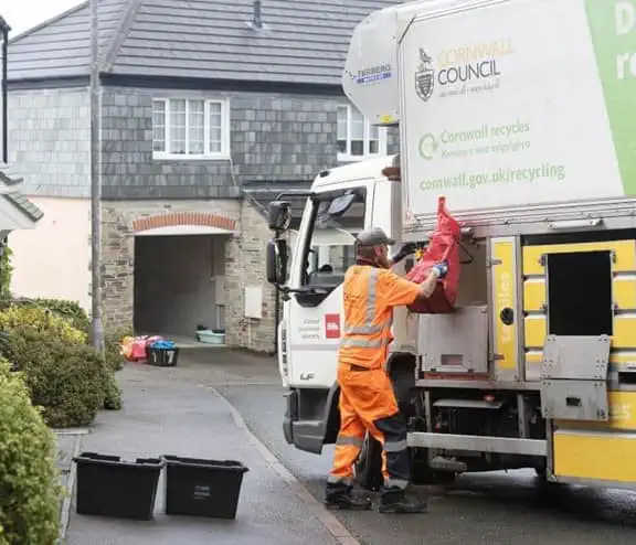 Employee loading bin bag into the back of truck