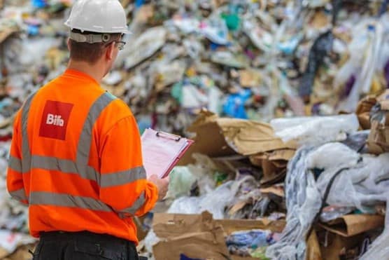 Person in Biffa high vis looking at mountain of waste