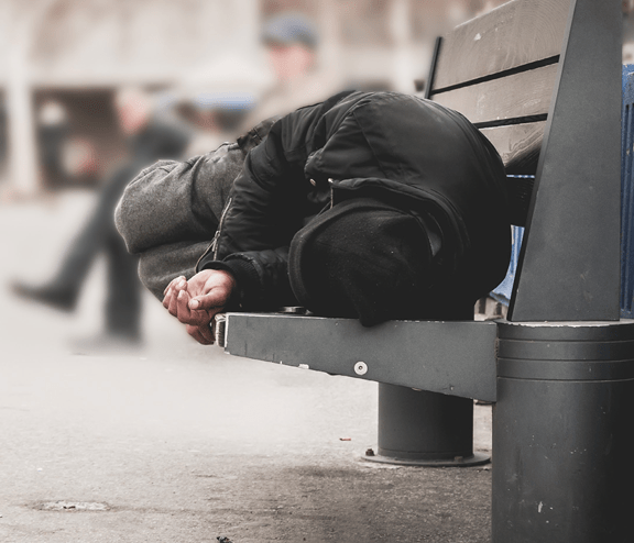 Homeless man sleeping on bench