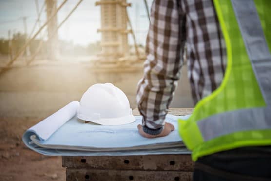 Man with high vis and hard hat on table