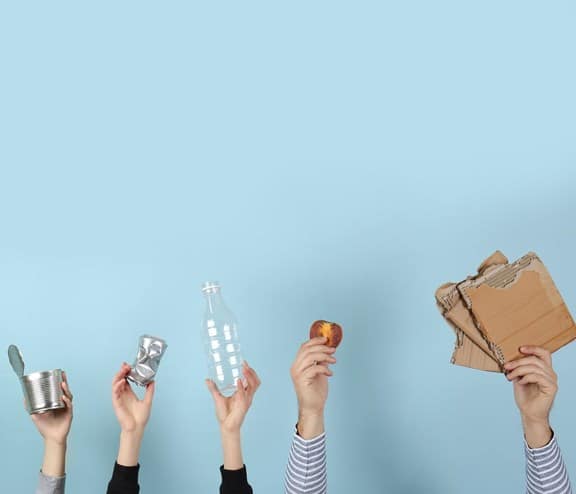 Different waste held up by hands